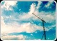 Tower crane jib against a bright sky with cloud.