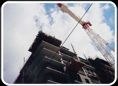 Tower crane climbing alongside a building under construction.