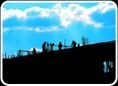 Workers silhouetted on a rooftop at dusk.