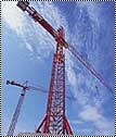 Tower crane mast and jib against open sky.