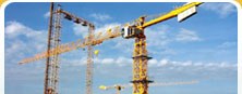 Two tower cranes erected over a construction site.